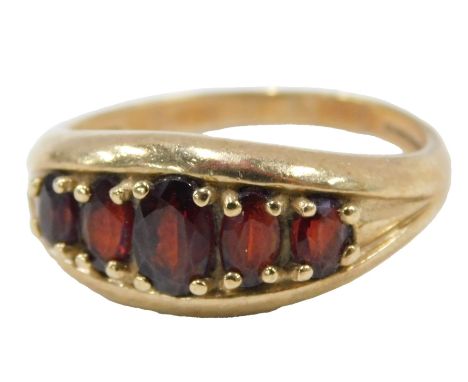 A 9ct gold garnet dress ring, set with five oval cut garnets, each claw set, on plain band, ring size R, 3.9g all in.