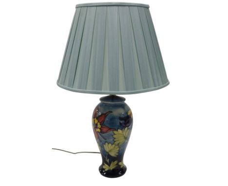 A Moorcroft pottery table lamp, decorated with purple, yellow and pink flowers and leaves, on a mottled ground, 42cm high to 