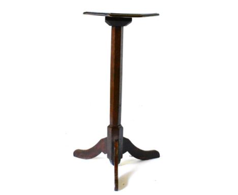 An 18th Century Joined Oak Tripod Candle Stand, the octagonal shaped four-pegged top above a chamfered support with three spl