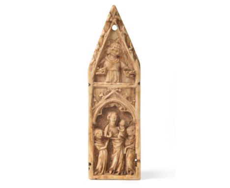 An Ivory Plaque, Northern French, 14th century, carved with the Madonna and Child flanked by two attendants within a Gothic a