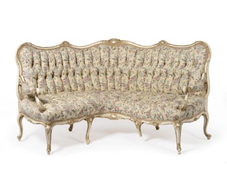 A 19th Century White Painted and Parcel Gilt Corner Sofa, in Louis XV style, recovered in cream, blue, pink and floral button