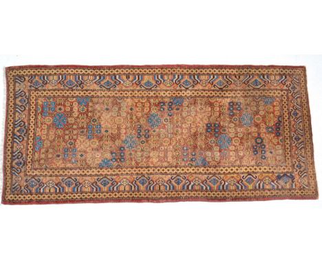 Khotan Carpet  East Turkestan, circa 1900 The terracotta field with a lattice of flowering angular vines enclosed by borders 