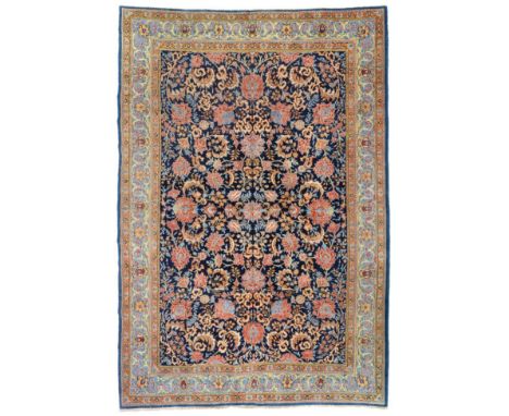 Ghom Carpet Central Iran, circa 1950 The indigo field with an allover design of large flowerheads and scrolling serrated leav