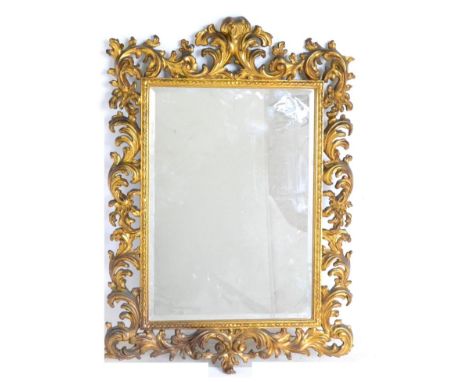 A Gilt and Gesso Wall Mirror, in rococo style, the bevelled glass mirror plate within an acanthus scrolled framed head by a d