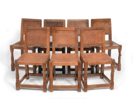 A Set of Seven Robert ''Mouseman'' Thompson Panel Back Oak Dining Chairs, with slung leather seats on octagonal front legs jo