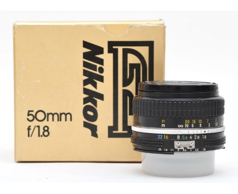 A Nikon Nikkor 50mm f1.8 lens, original box with manual, working with a faint haze in the lens 