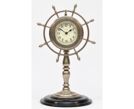 A novelty presentation chromed desk clock, in the form of a ships wheel, raised on a Japaned base, 26cm. Inscribed "Mr. W.F.A