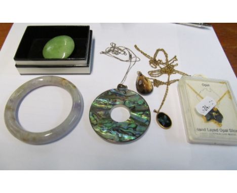 A jade brooch, jade bangle, mother of pearl pendant on chain and three pendants on chain
