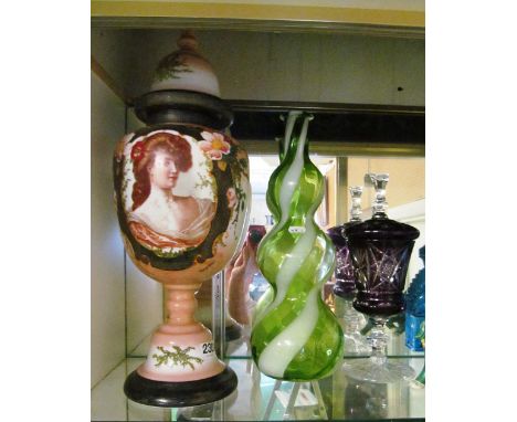 A decorative glass lidded vase with scene of Victorian lady, a green and white swirl pattern vase and amethyst lidded glass v