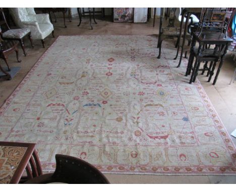 A Chinese beige ground wool carpet with design of red, yellow and beige flowers 9' x 12'