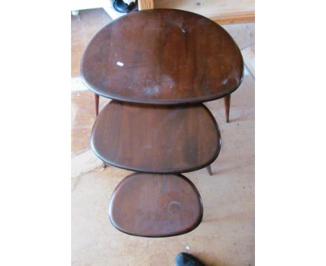 A nest of three dark wood Ercol pebble tables