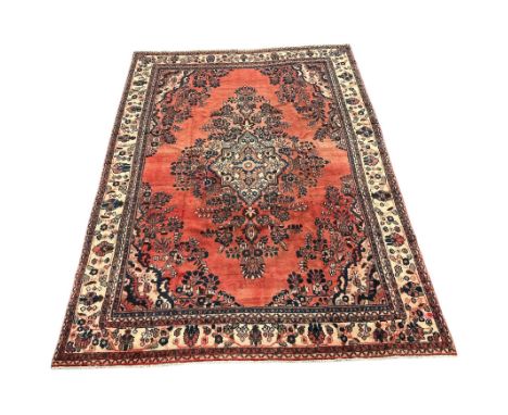 A Persian Tabriz carpet with central floral medallion and floral corners within borders, on a beige ground, 244 by 330cms.