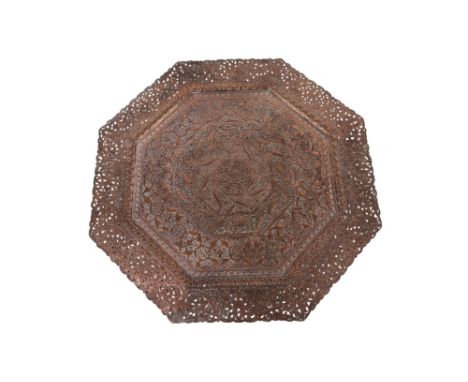 A Persian pierced copper tray of octagonal form decorated with scrolling foliage, 62cms wide.