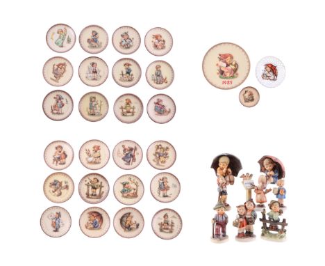 A group of Hummel miniature year plates with wall mounted display racks; together with a group of Goebel figures and similar 