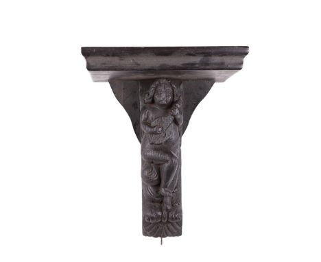 An 18th century figural oak wall bracket, 35cms high.
