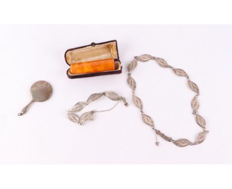 A cased amber cigar holder; together with a miniature chatelaine silver hand mirror and a filigree silver necklace and bracel