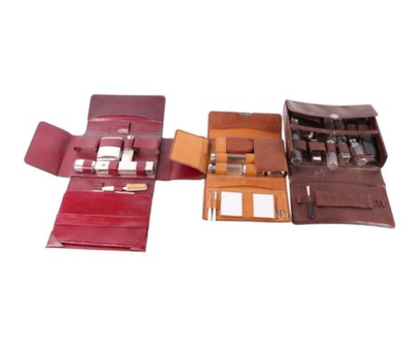 A vintage leather gentleman's travelling vanity case with fitted interior, 32cms wide; together with two similar (3). Provena