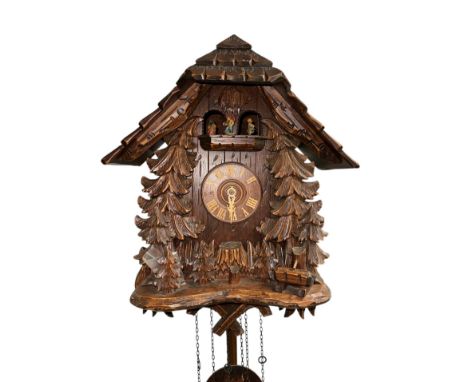 A Black Forest cuckoo clock with three-train movement, 38cms wide.