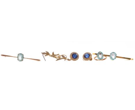 TWO EARLY TWENTIETH CENTURY BAR BROOCHES,each set with oval blue gems and marked 9CT, a floral spray brooch marked 9CT, a nin
