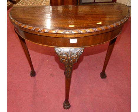 A mid 20th century mahogany demi lune fold-over card table, having a baize lined interior, gadrooned edge, on slender cabriol