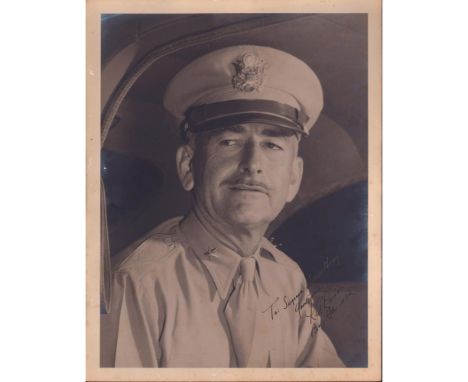 Large signed dashing portrait of a WWII Brigadier General in military cap, tie, and button shirt seated in vehicle.Silver gel