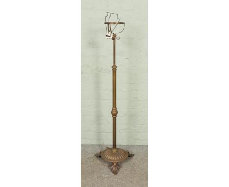 A brass rise and fall standard lamp with foliate design feet