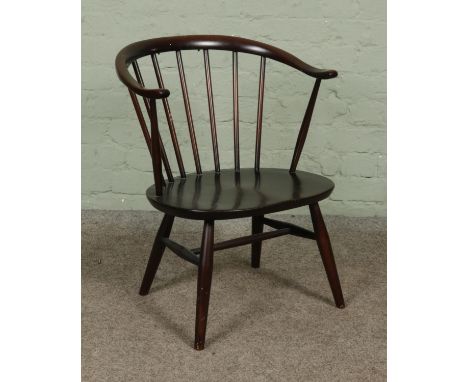 A dark Ercol model 338 'Cowhorn' elbow armchair, bearing kitemark to the underside of the base.  Some wear to the top.