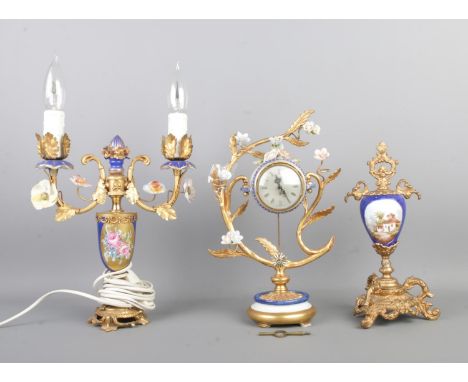 A 'Walt' gilt metal and ceramic eight day clock, together with a similar style urn with hand painted panel and twin branch ca