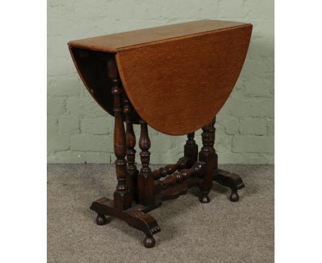 A small oak drop leaf gate leg table, featuring turned supports. Raised on ball feet. Height: 69cm, Width (extended): 89cm, D