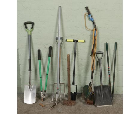 A collection of mixed garden tools, including electric Vergemaster edge trimmer, snow shovel, garden spade, edging shear, sle