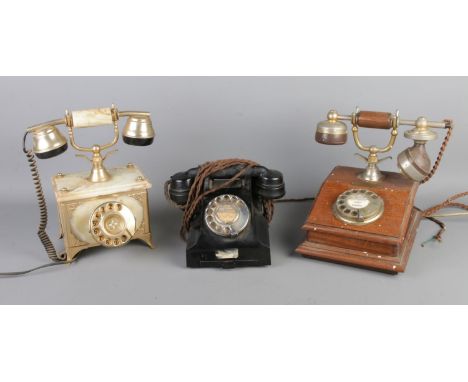 Three vintage rotary telephones, including oak cased and onyx examples.