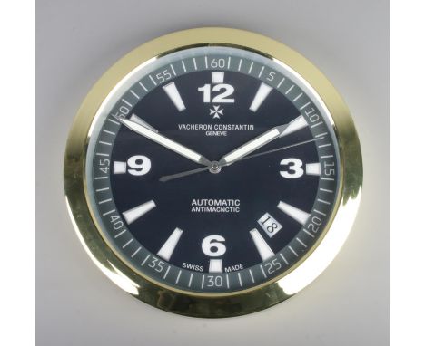 A Vacheron Constantin style wall clock, gold bezel with black  dial, featuring baton and Arabic Numeral markers.