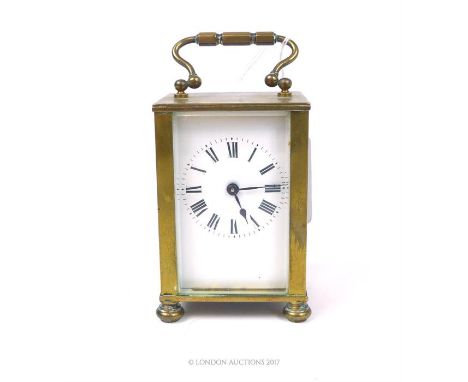 A brass carriage clock, having a swing handle to the top and Roman numerals to the enamelled dial, 13 x 7 x 6cm.