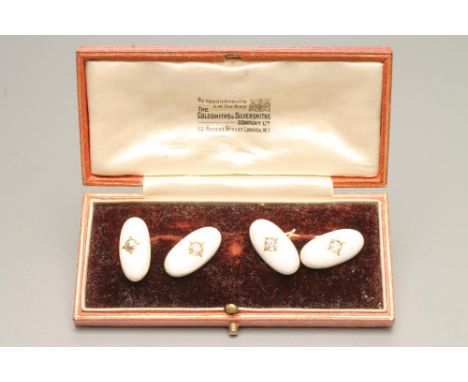 A PAIR OF FRENCH CUFFLINKS, the oval white enamel panels impressed to resemble a cotton weave each centred by an old brillian