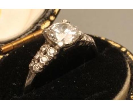 A SOLITAIRE DIAMOND RING, the round brilliant cut stone of approximately 0.75cts claw set to shoulders each set with three pa