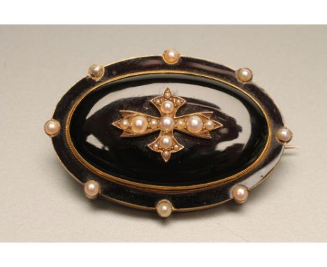 A VICTORIAN MOURNING BROOCH, the oval black onyx panel centred by a seed pearl cross within an enamel border and eight furthe