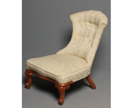 A VICTORIAN WALNUT FRAMED NURSING CHAIR button upholstered in an ivory floral weave, arched waisted upholstered back, overstu