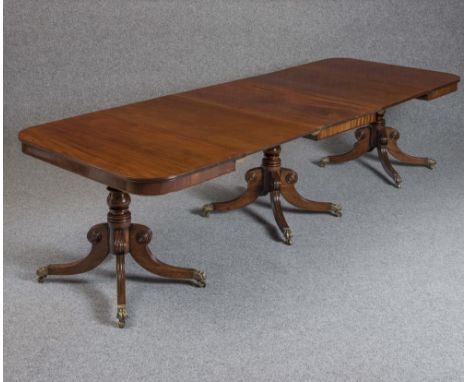 A GEORGIAN MAHOGANY TRIPLE PILLAR DINING TABLE, late 18th century, of rounded oblong form, the moulded edged top with plain f