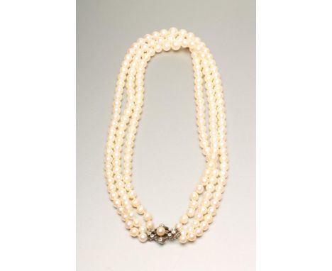 A TRIPLE GRADUATED STRAND CULTURED PEARL NECKLACE, the 15"-18" long strands with diamond set open clasp centred by a pearl (E