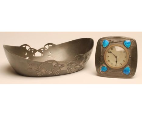 A TUDRIC PEWTER AND ENAMEL DESK CLOCK, the silvered circular dial with black Arabic numerals contained in a rounded square st