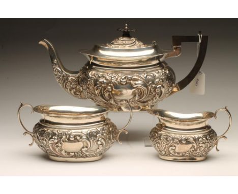 AN EDWARDIAN SILVER THREE PIECE TEA SERVICE, maker's mark RC, Birmingham 1904, of rounded oblong baluster form, chased with s