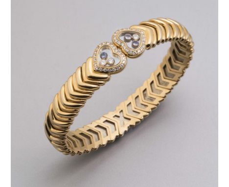 A CHOPARD 18CT GOLD AND DIAMOND BANGLE, the flexible herringbone links with glass heart terminals (one engraved Chopard), the