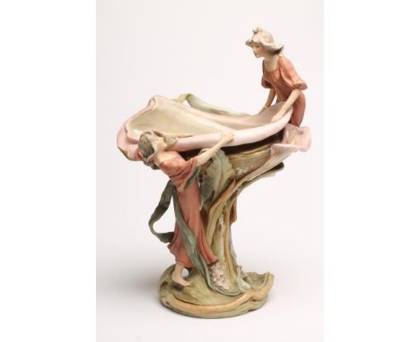 AN ART NOUVEAU ROYAL DUX BISQUE PORCELAIN FIGURAL CENTREPIECE, modelled as two maidens overlooking a shaped bowl raised upon 