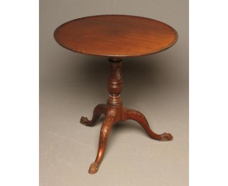 A MAHOGANY TRIPOD TABLE of Georgian design, late 19th century, the dished circular top with flower carved rim, spiral fluted 