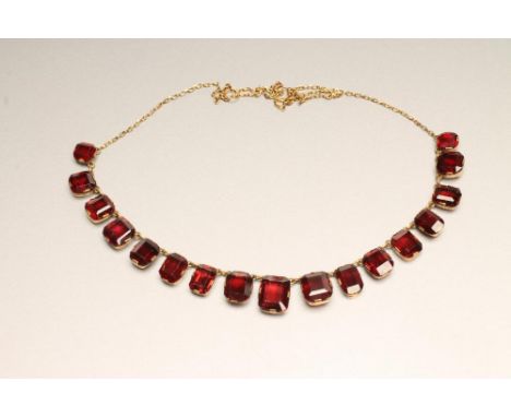 A VICTORIAN GARNET NECKLACE, the seventeen square and oblong facet cut graduated stones claw set to a fine chain necklace (la