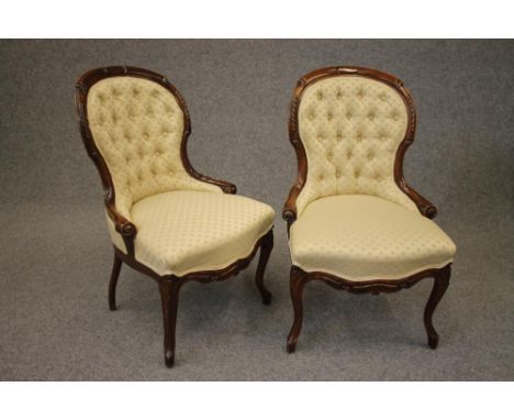 A PAIR OF VICTORIAN WALNUT FRAMED PARLOUR CHAIRS of spoonback form button upholstered in a cream weave, channelled frame carv