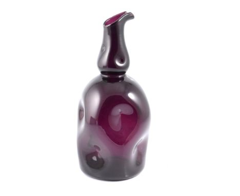 A dimpled amethyst glass pitcher/ carafe, probably American, possibly Fenton or Blenko, mid 20th century, with slightly swoll