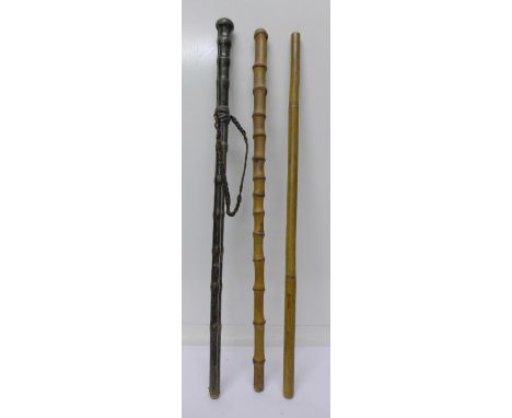 A leather covered bamboo swagger stick and two other bamboo swagger sticks