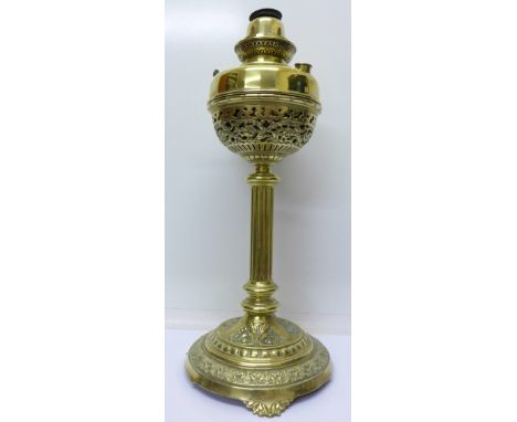 A brass oil lamp, lacking shade and chimney