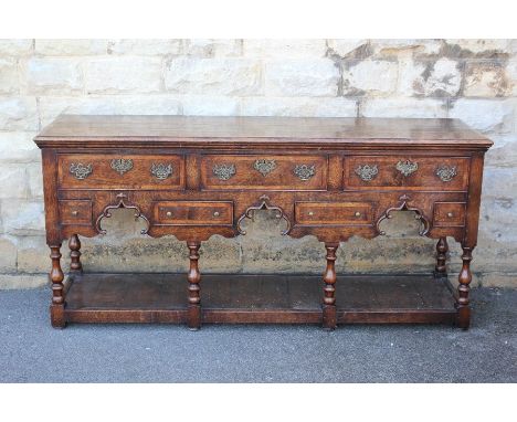 An Oak Bylaws Knell Dresser . The dresser is based on a traditional English design, having three cutlery drawers, with four s